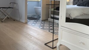 A modern bedroom with a bed, a TV mounted on the wall, a chair, and a small table. - B&B Aline Florentine (Kortenberg)