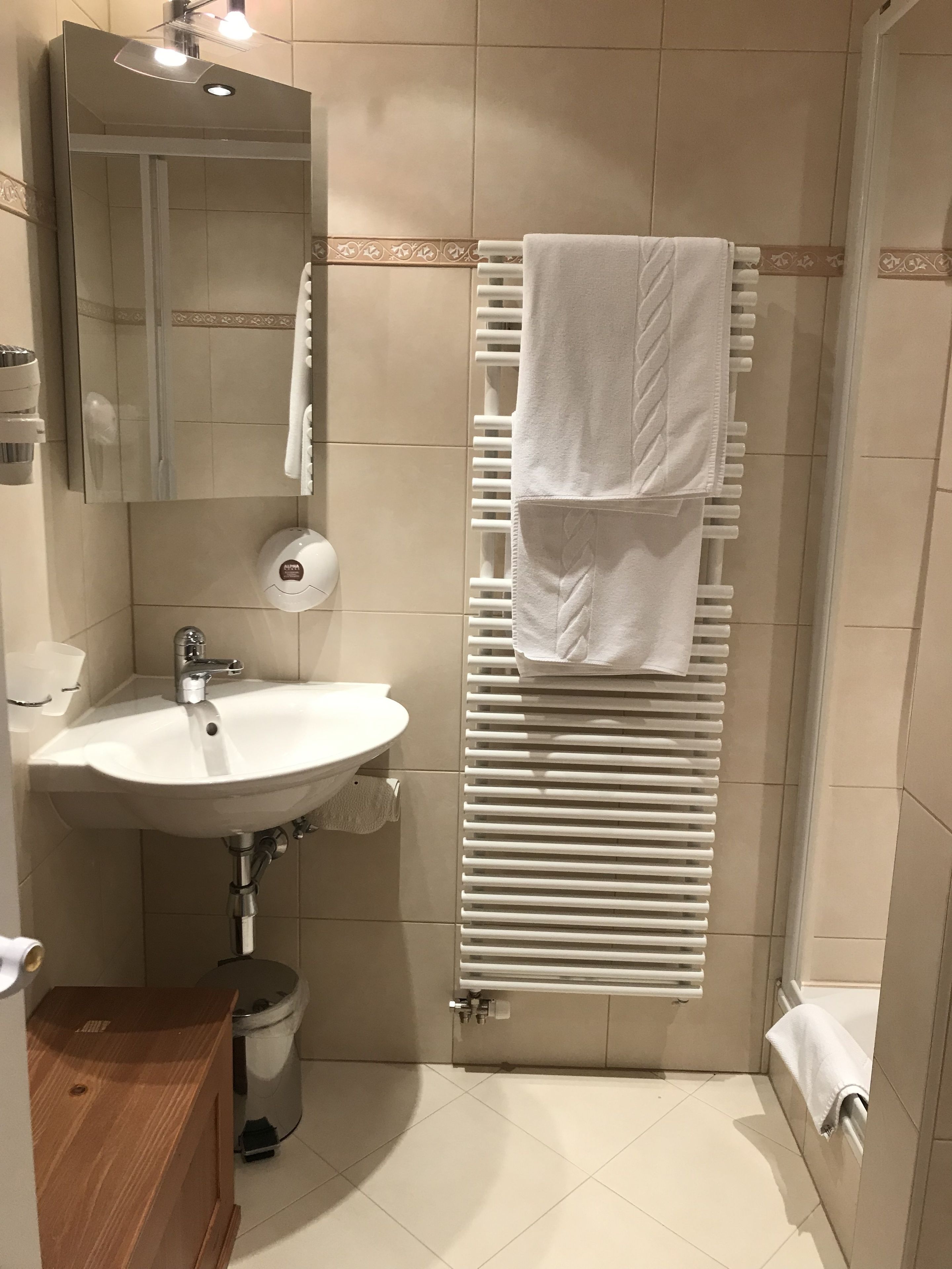 Une salle de bain équipée d’un lavabo, d’un miroir, d’un porte-serviettes et de toilettes.