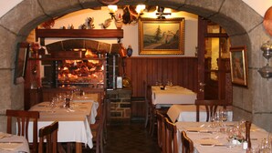 Un restaurante con arcos de piedra, mesas de madera y una chimenea de piedra.