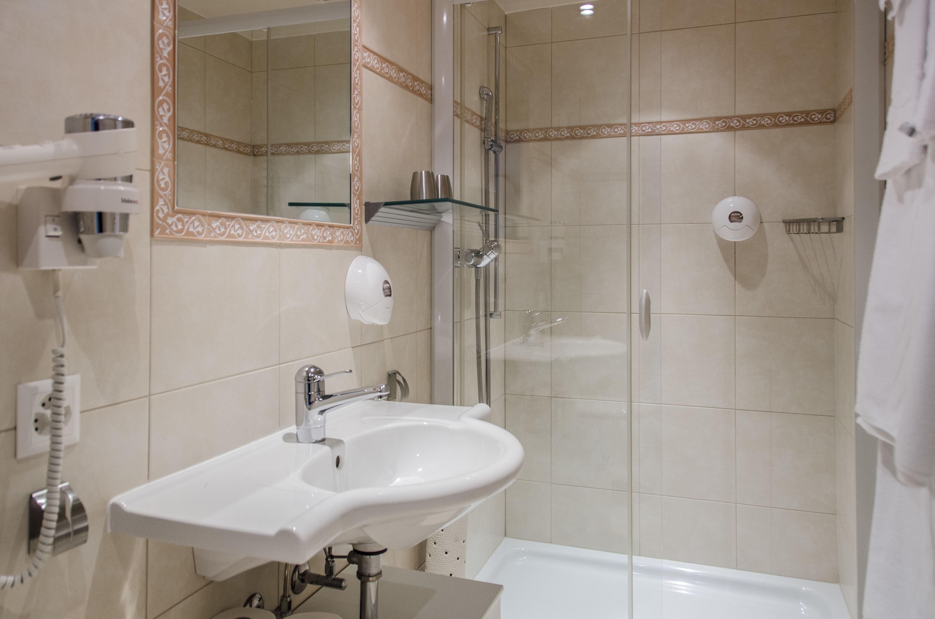 A bathroom with a white sink, a glass shower enclosure, and a bathtub.