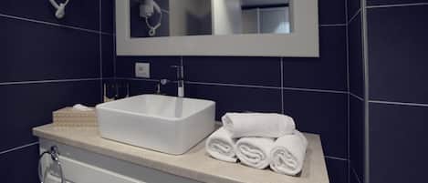 A bathroom with a white sink, a mirror, and a towel rack.