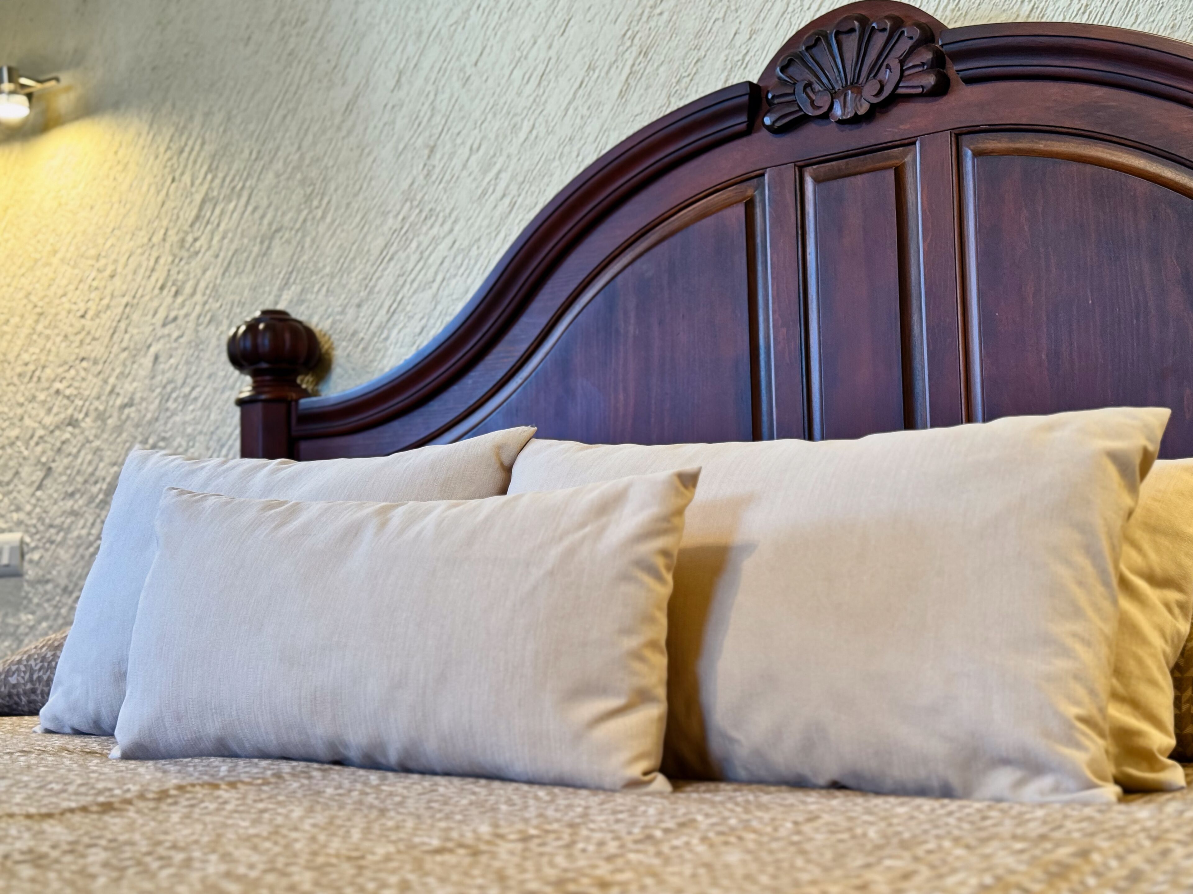 Ein Bett mit einem hölzernen Kopfende und zwei Kissen.