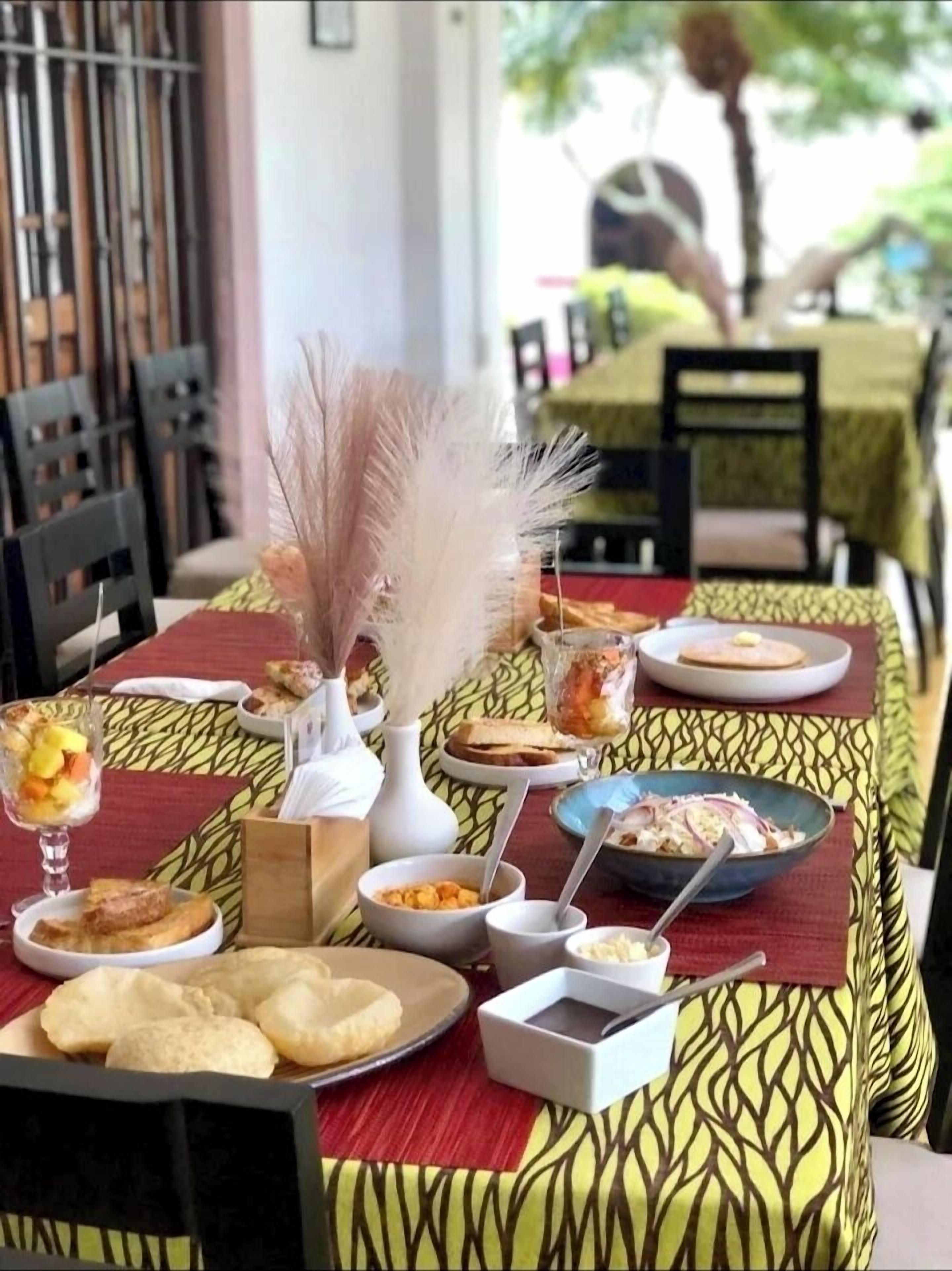 A table set with various dishes, including bread, a salad, and a dessert in a glass.