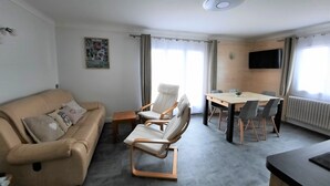 A modern living room with a sofa, a dining table, and two chairs. - Ski in ski out Apartment LYS ORANGES, for your holidays in MEGEVE, 4 p (Megève)