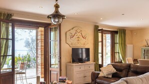 Ein Wohnzimmer mit Sofa, Fernseher und einer Wanddekoration.