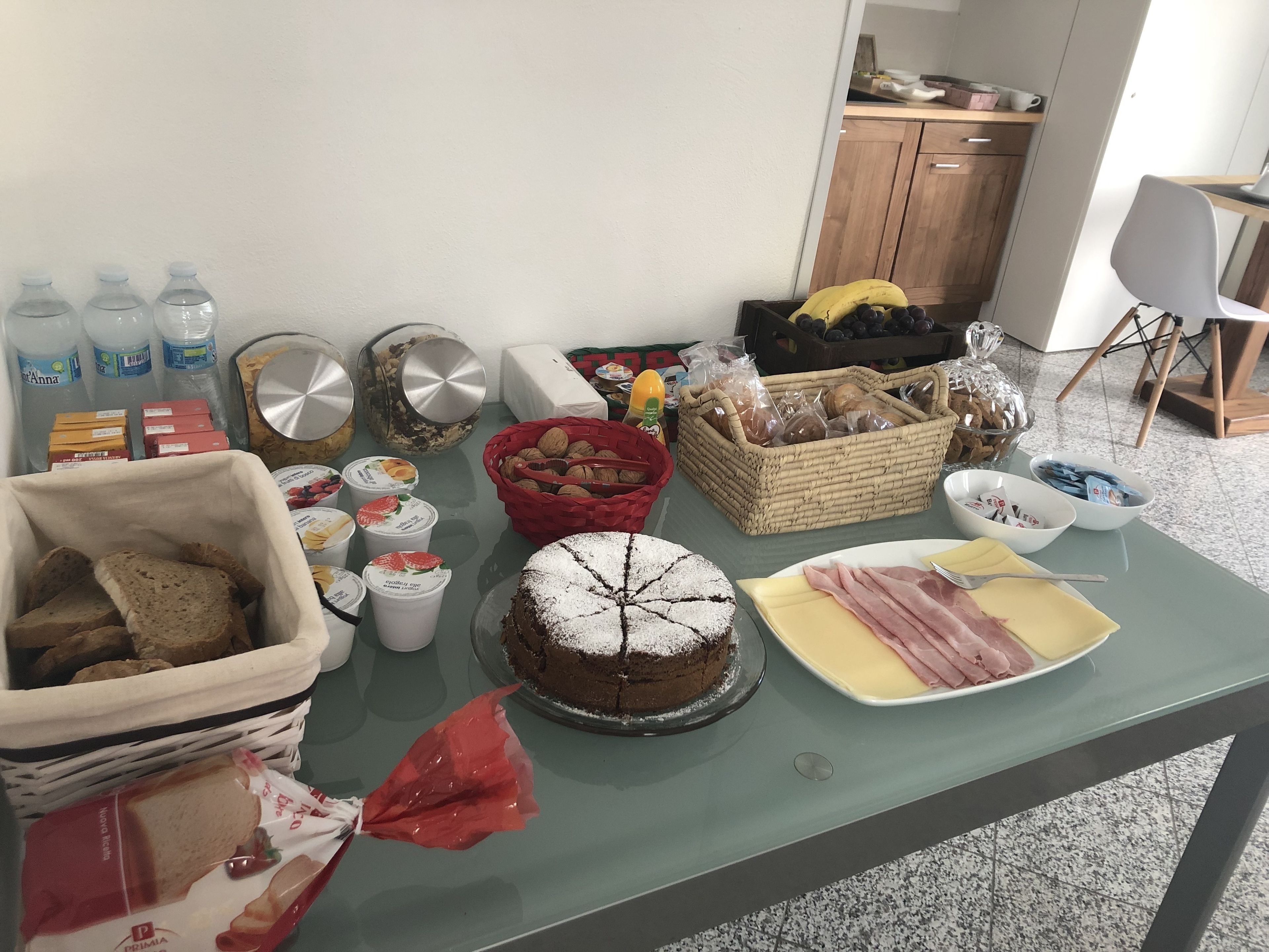 Ein Tisch mit verschiedenen Speisen, darunter Brot, Kuchen und Milchprodukte.