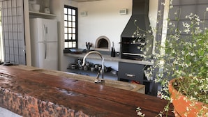 A modern kitchen with a large island, built-in oven, and a black range hood. - Latitude Lodge (Cunha)
