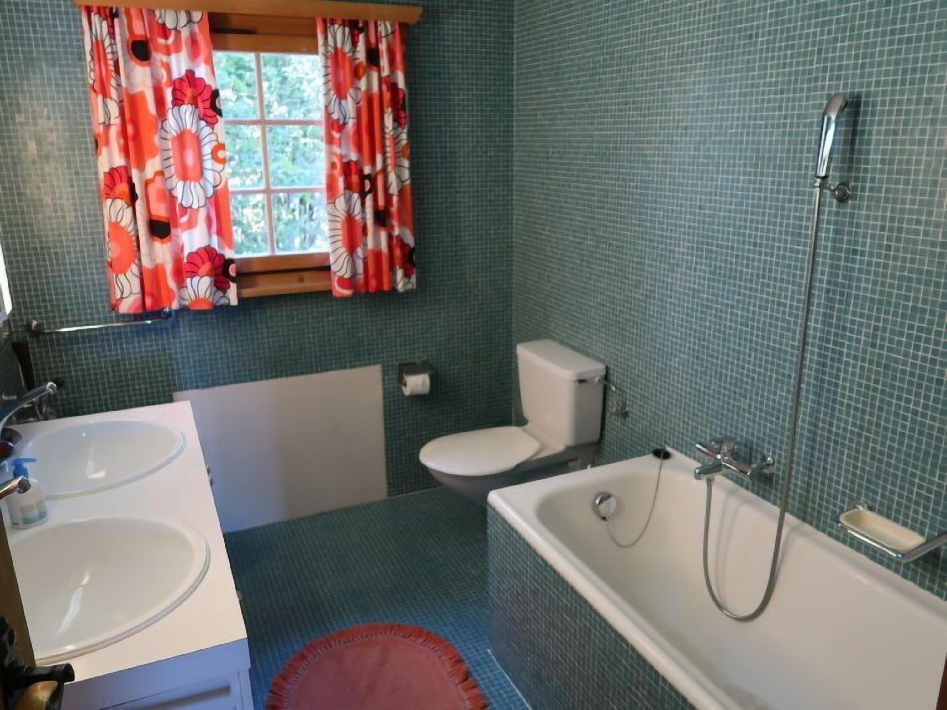A bathroom with two sinks, a toilet, and a bathtub.