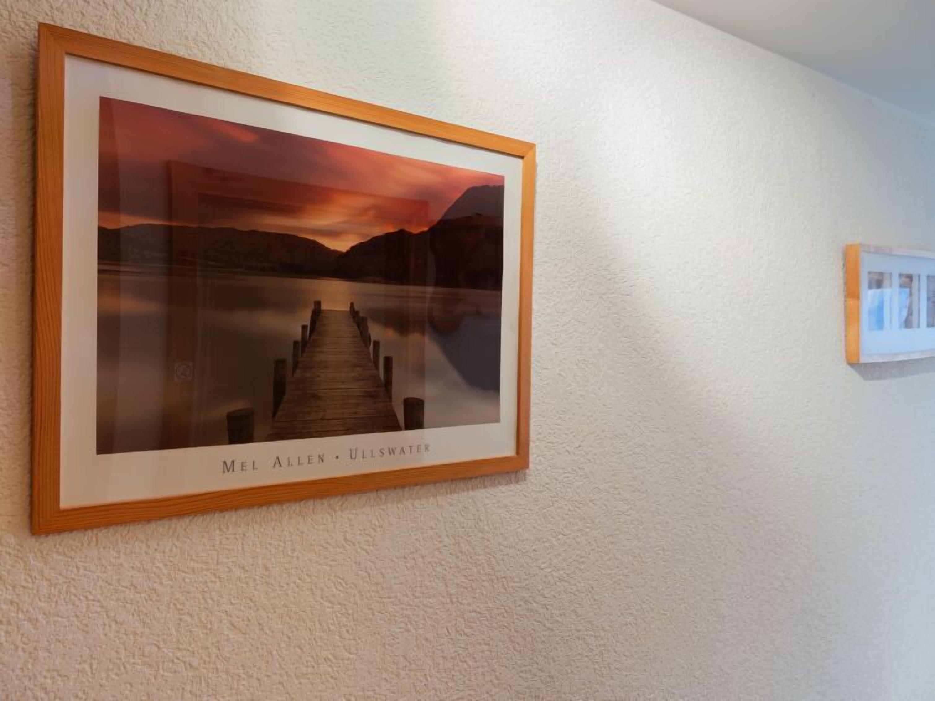 A framed photograph of a sunset over a lake with a pier, titled 'MEL ALLEN - ULLSWATER'.