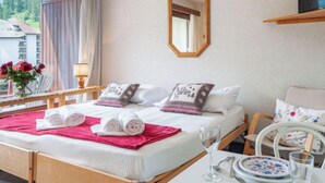 A hotel room with a bed, a bedside table with a lamp, a mirror, and a window with curtains. - Rosablanche B72 by Interhome (Siviez-Nendaz)