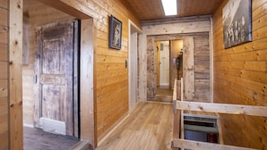 A wooden interior with a hallway leading to a bathroom.