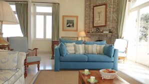 Una sala de estar con un sofá azul, una mesa de centro de madera y una chimenea.