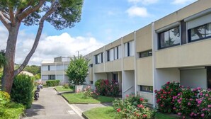 Uma fileira de edifícios modernos, com dois andares, e um caminho central.