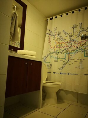 A bathroom with a toilet, a mirror, and a cabinet. - Apart Merced (Santiago)