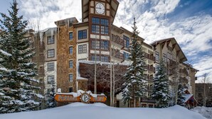 Un hôtel à plusieurs étages, doté d’un imposant clocher, d’arbres couverts de neige et d’une enseigne indiquant « Passage Point ».