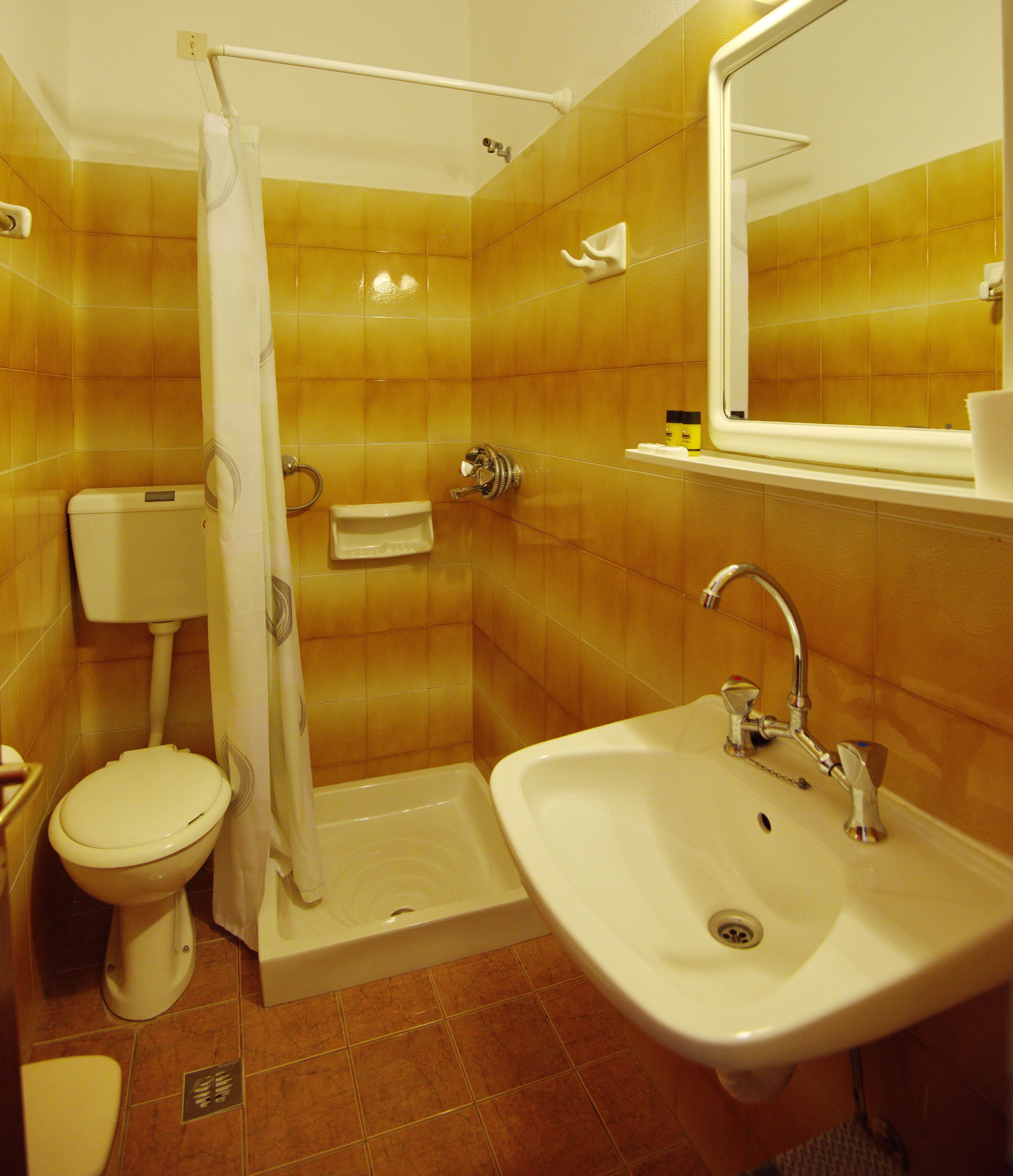 A bathroom with a toilet, sink, and shower.