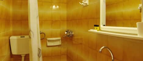 A bathroom with a toilet, sink, and shower.