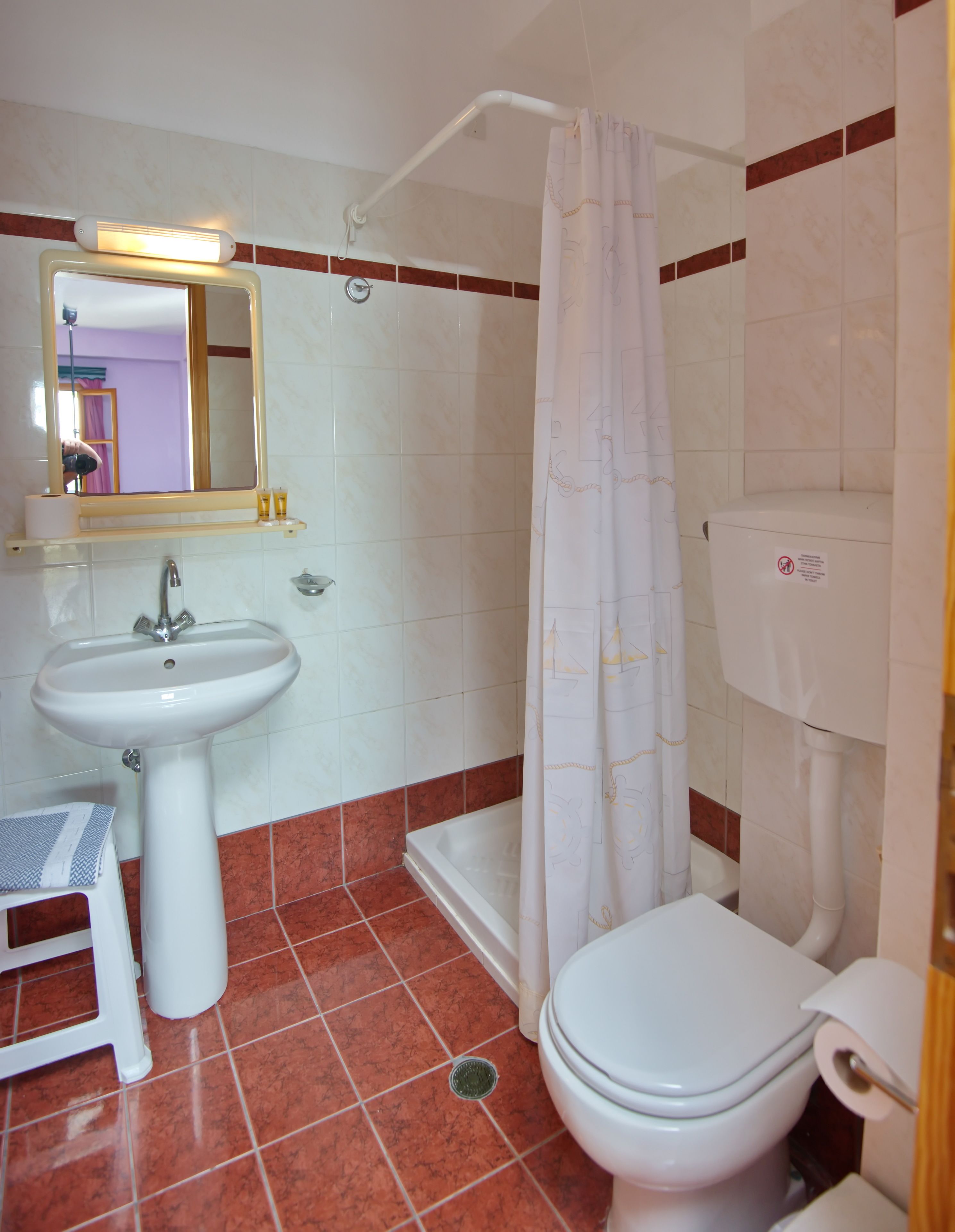 A bathroom with a sink, toilet, and shower.