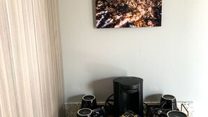Een keuken met een koffiehoek, een koffiezetapparaat en een decoratief object op het aanrecht.