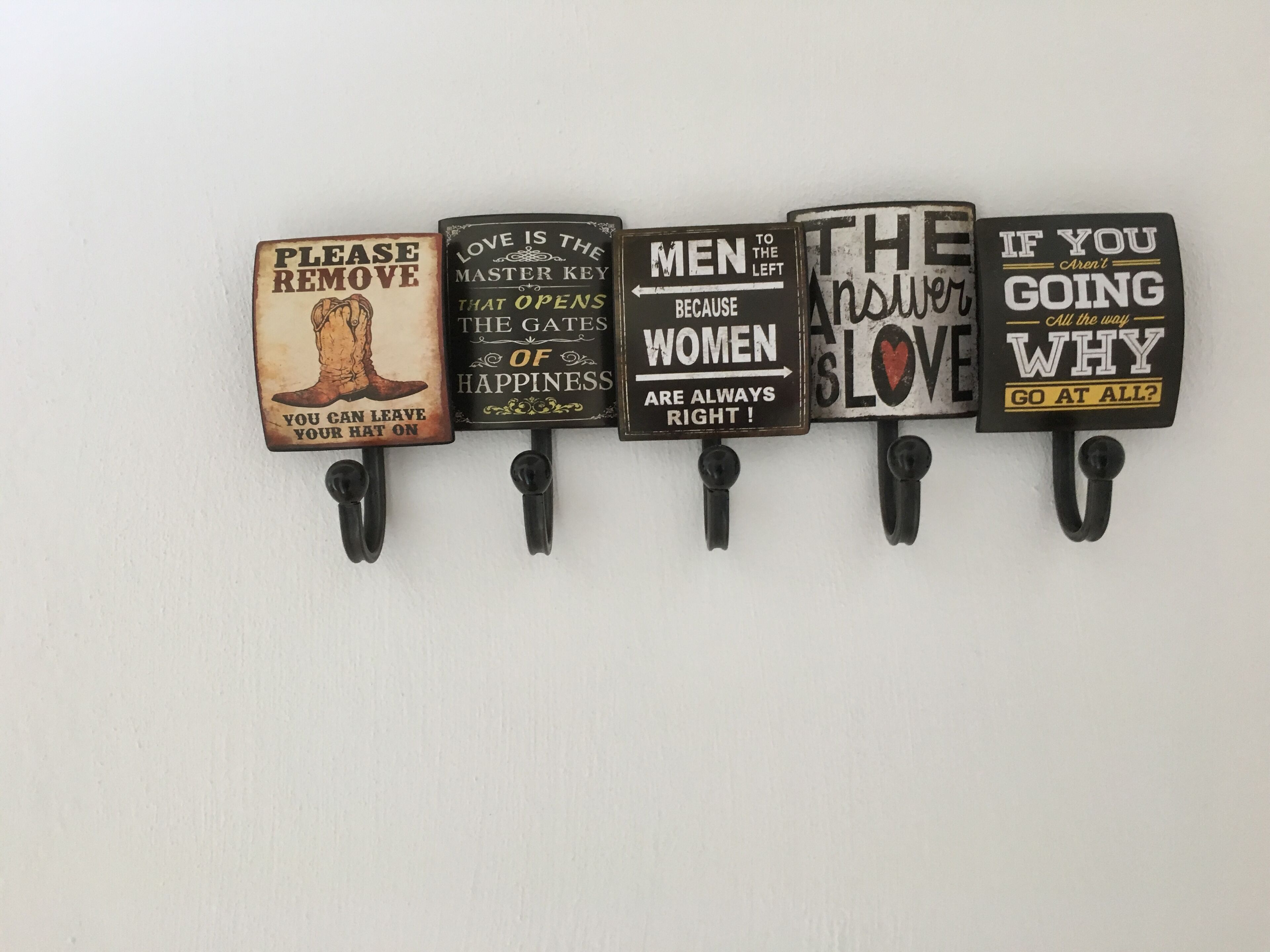 Una pared con cinco letreros, cada uno con mensajes y diseños diferentes.