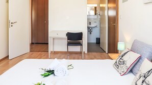 A hotel room with a bed, a desk, a chair, and a bathroom visible through an open door. - Rosablanche A24 by Interhome (Siviez-Nendaz)