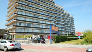 A multi-story hotel with a modern design, featuring balconies on each floor.