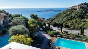 Une vue sur la côte, avec une piscine, une route et des bâtiments situés sur une colline.