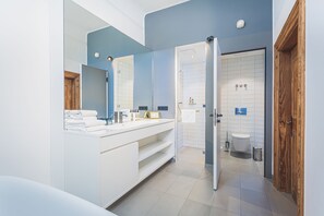 A modern bathroom with a large mirror, white vanity, and a separate toilet area. - Romantik Hotel Alte Posthalterei (Zusmarshausen)