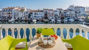A terrace with a table set for two, overlooking a marina with boats and buildings in the background. - Port Banyuls by Interhome (Empuriabrava)