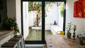A modern kitchen with a skylight, a dining area with stools, and a view of the garden. - Luxury 4BDR cottage right in the heart of Brighton (Brighton)