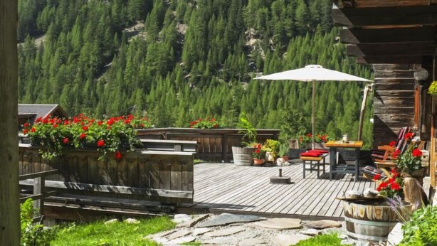 A wooden deck with outdoor seating, surrounded by a mountainous landscape. - Beim Holzschnitzer by Interhome (Sölden)
