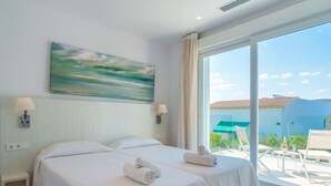 Habitación de hotel con dos camas, un ventanal grande y vistas al exterior.
