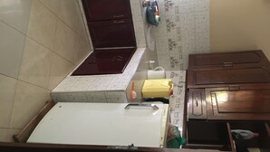 A kitchen with a white refrigerator, wooden cabinets, and a tiled backsplash.