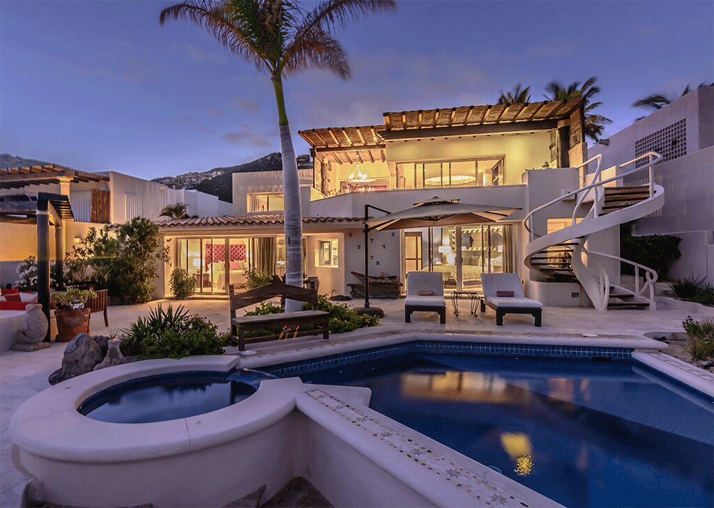 A modern house with a swimming pool, outdoor seating, and a spiral staircase.