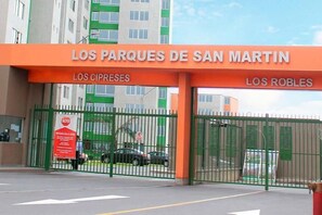 A gated entrance with signage for 'Los Parques de San Martin' and 'Los Cipreses.'