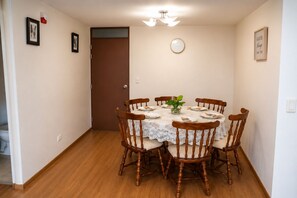 A dining room with a round table, six wooden chairs, a white lace tablecloth, a clock, and a framed quote on the wall. - Moderno y Acogedor  3 Habitaciones  Cerca del Centro Histórico de Lima (Cercado de Lima)