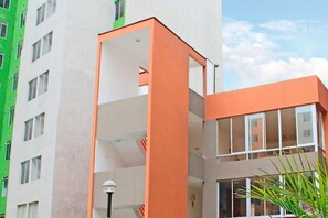 A multi-story building with a prominent orange structure, large windows, and a visible balcony. - Moderno y Acogedor  3 Habitaciones  Cerca del Centro Histórico de Lima (Cercado de Lima)