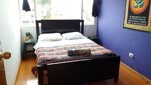 Cubrecamas, muebles diferentes y tabla de planchar con plancha