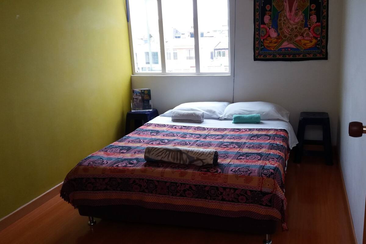 Cubrecamas, muebles diferentes y tabla de planchar con plancha