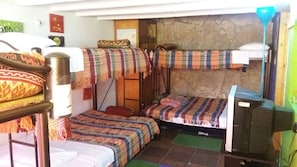 Cubrecamas, muebles diferentes y tabla de planchar con plancha