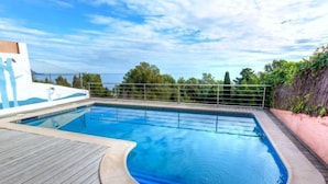 A swimming pool with a wooden deck and a view of the sea. - Apartment Fane by Interhome (Llançà)