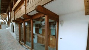 Un bâtiment doté d’une entrée en arc de pierre, de poutres en bois et d’une porte en verre.