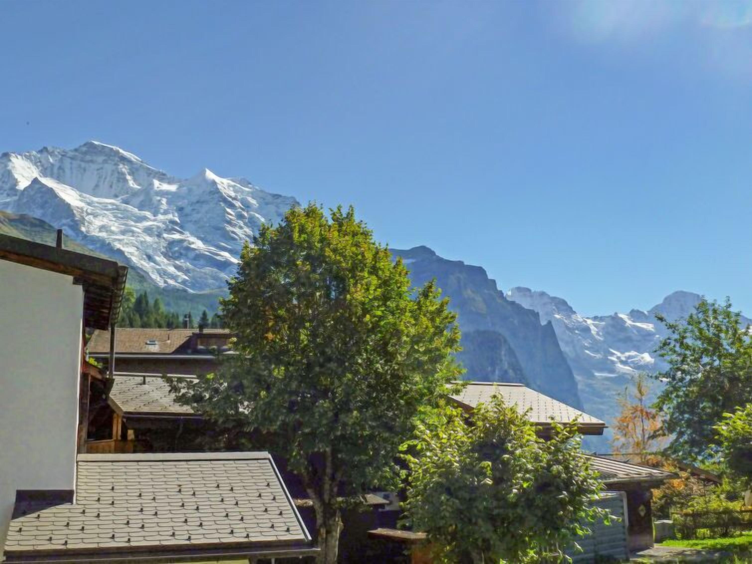 Een bergdorp met traditionele gebouwen en een met sneeuw bedekte berg op de achtergrond.