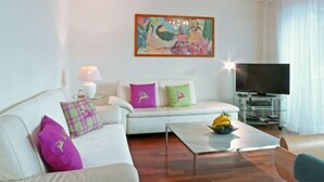 Una sala de estar moderna con un sofá, una mesa de centro y un televisor de pantalla plana.
