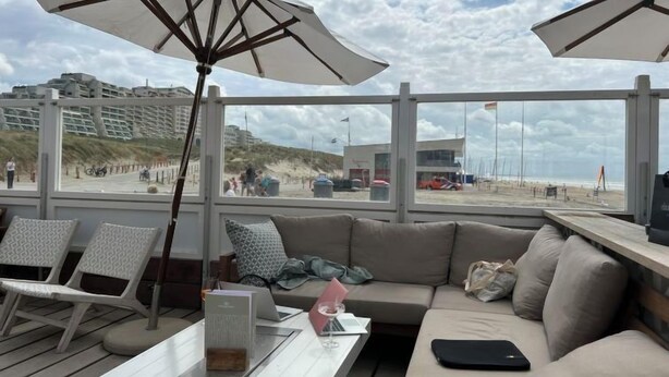 A beachside lounge with a sofa, chairs, and umbrellas. - Plevier Comfort by Interhome (Noordwijk)