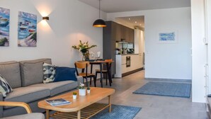 Een moderne woonkamer met een bank, salontafel en kunstwerk aan de muur.