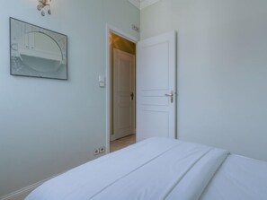 Ein Schlafzimmer mit einem Bett, einer Tür und einer Wandleuchte.