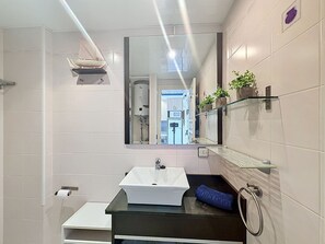 Ein modernes Badezimmer mit Waschbecken, Spiegel und Dusche.