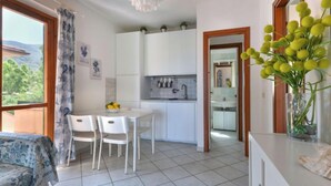 Una cocina moderna con armarios blancos y una zona de comedor con mesa y sillas.