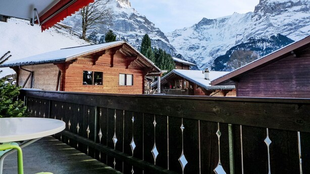 A wooden chalet with a balcony overlooking a snowy mountain landscape. - Chalet Bienli Mitte by Interhome (Grindelwald)